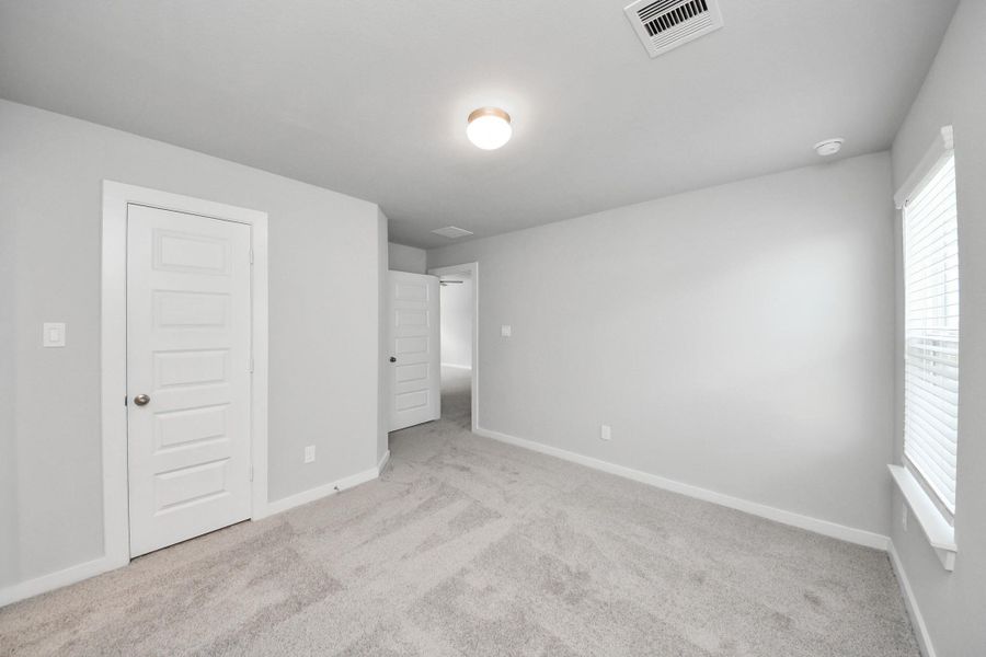 Generously sized secondary bedrooms featuring spacious closets, soft and inviting carpeting underfoot, large windows allowing plenty of natural light, and the added touch of privacy blinds for your personal retreat. Sample photo of completed home with similar floor plan. Actual colors and selections may vary.