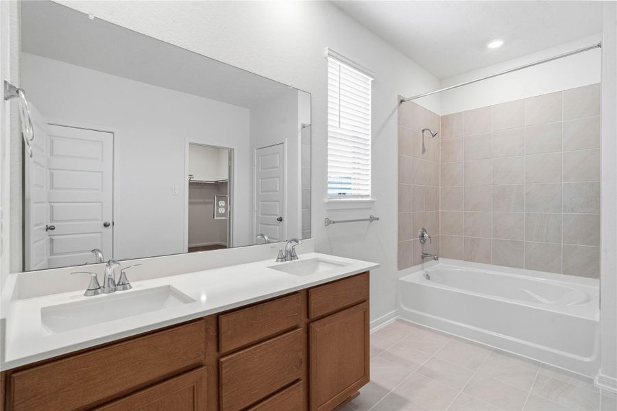 This stunningly updated primary bathroom is truly move-in ready! It features stained cabinetry with light countertops, dual sinks, a large mirror, high ceilings, custom paint, tub/shower combination with tile surround, and sleek modern finishes throughout. This stunningly updated primary bathroom is truly move-in ready! It features stained cabinetry with light countertops, dual sinks, a large mirror, high ceilings, custom paint, tub/shower combination with tile surround, and sleek modern finishes throughout.