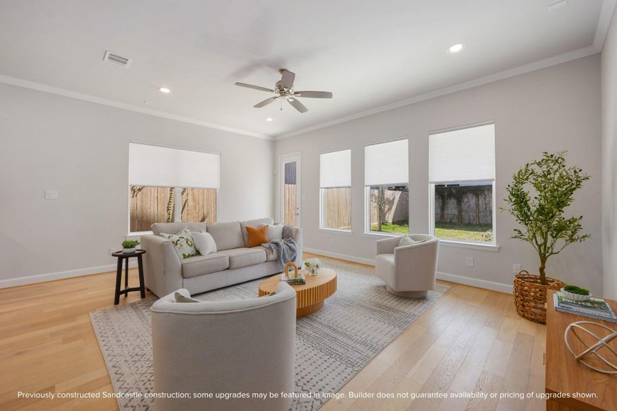 A wall of windows bathes the living room in natural light, offering serene views of the tranquil backyard. A wall of windows bathes the living room in natural light, offering serene views of the tranquil backyard.