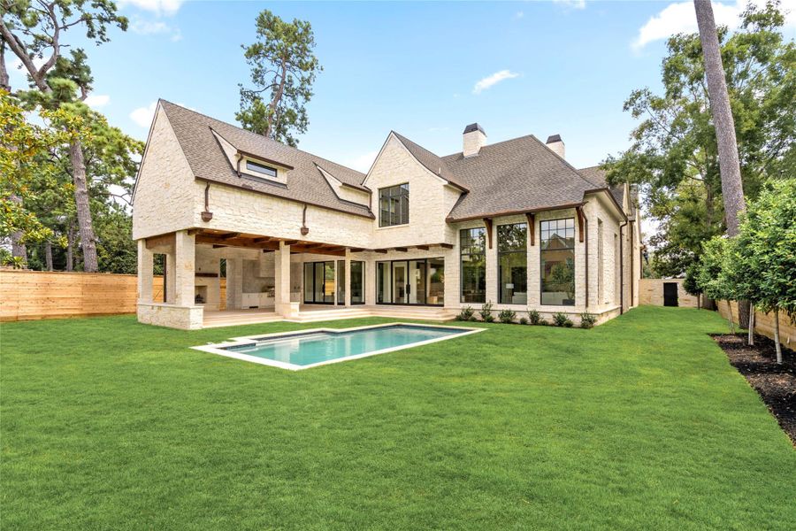 The rear elevation opens beautifully to the pool and expansive lawn, with walls of steel-framed windows and doors creating a strong connection to the outdoors. A generous covered loggia with a summer kitchen extends the living space outside, while the home’s limestone exterior and warm wood detailing carry the architecture seamlessly around the property. The rear elevation opens beautifully to the pool and expansive lawn, with walls of steel-framed windows and doors creating a strong connection to the outdoors. A generous covered loggia with a summer kitchen extends the living space outside, while the home’s limestone exterior and warm wood detailing carry the architecture seamlessly around the property.
