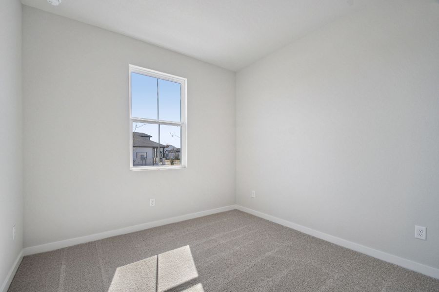 A room with a window and a rug.