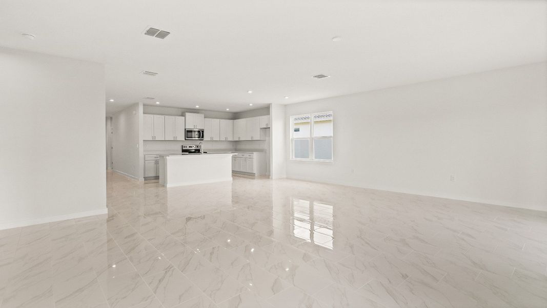 Bright open-concept layout with tile floors and modern kitchen in the Castaway model by DRB Homes at Hamilton Bluff