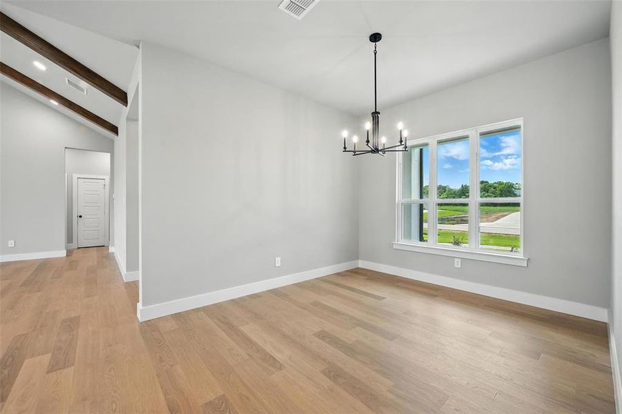 Unfurnished room with a chandelier and light wood-style floors Unfurnished room with a chandelier and light wood-style floors