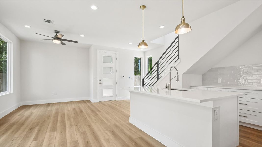 Kitchen featuring pendant lighting, tasteful backsplash, white cabinets, recessed lighting, and an island with sink Kitchen featuring pendant lighting, tasteful backsplash, white cabinets, recessed lighting, and an island with sink