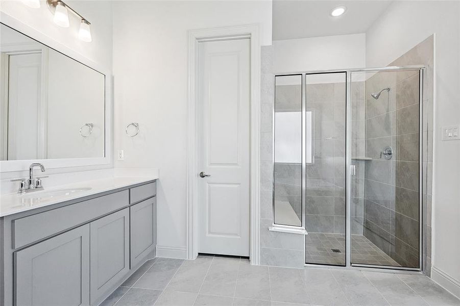 Bathroom with vanity, a stall shower, light tile patterned flooring, and recessed lighting