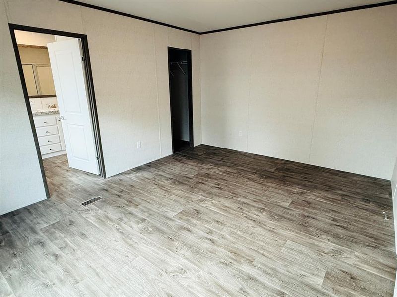 Unfurnished bedroom featuring light wood-type flooring and ornamental molding