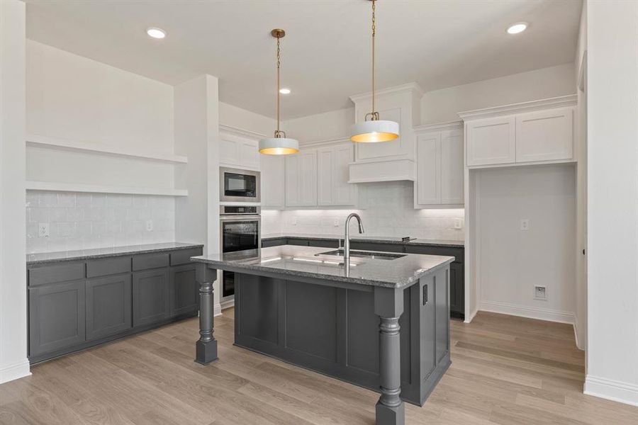 Kitchen featuring light stone counters, open shelves, a sink, light wood-type flooring, and black microwave