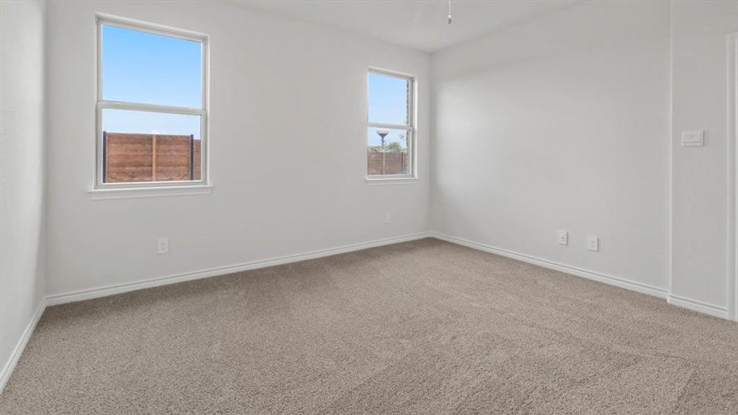 Empty room featuring light carpet and baseboards