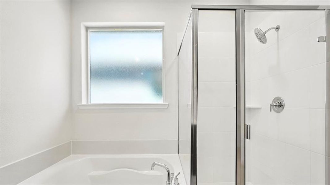 Soaking tub with frosted window, separate shower with glass enclosure, white subway tile, and chrome fixtures
