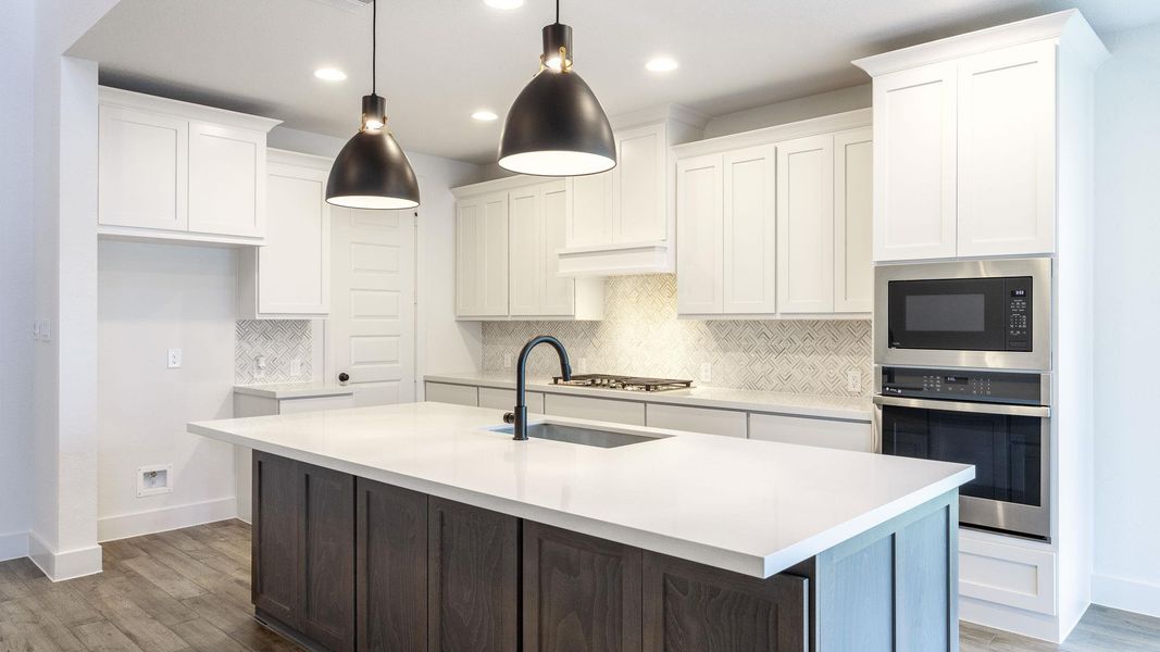 Kitchen featuring tasteful backsplash, appliances with stainless steel finishes, dark wood-style flooring, white cabinets, and an island with sink Kitchen featuring tasteful backsplash, appliances with stainless steel finishes, dark wood-style flooring, white cabinets, and an island with sink