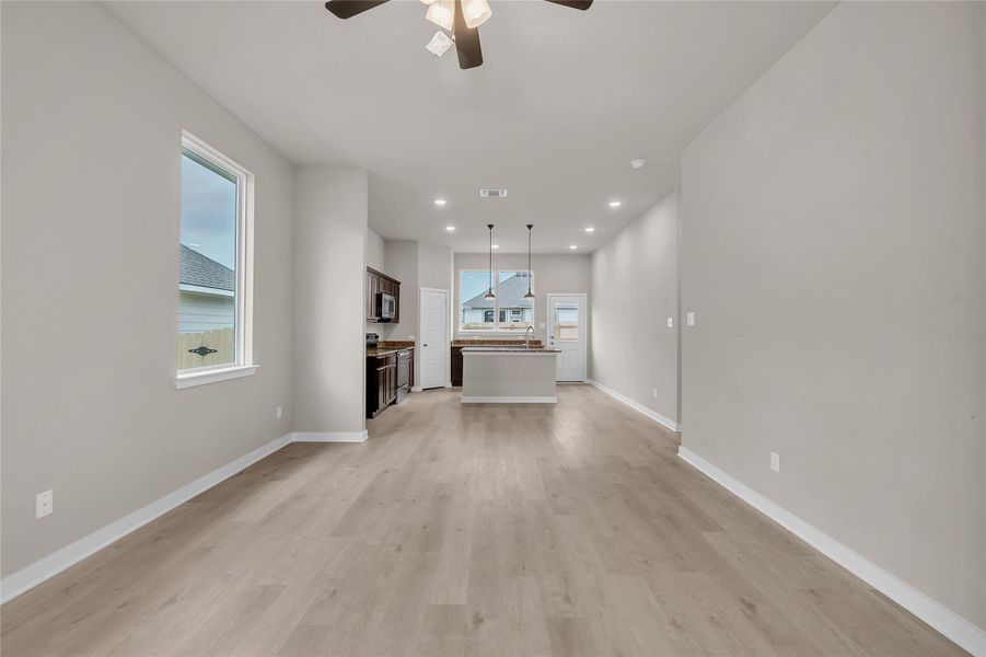 Unfurnished living room featuring ceiling fan, light wood-style floors, and recessed lighting