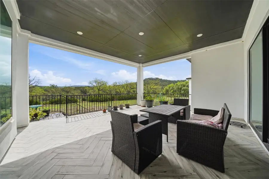 The property features an expansive covered patio with a dark ceiling and recessed lighting