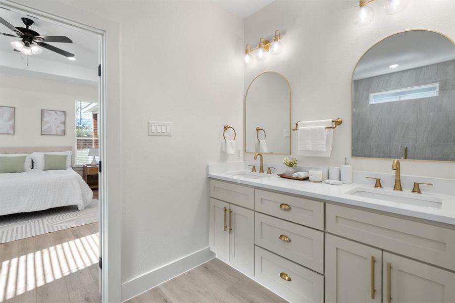 Bathroom with plenty of natural light, double vanity, light wood-style floors, and connected bathroom Bathroom with plenty of natural light, double vanity, light wood-style floors, and connected bathroom