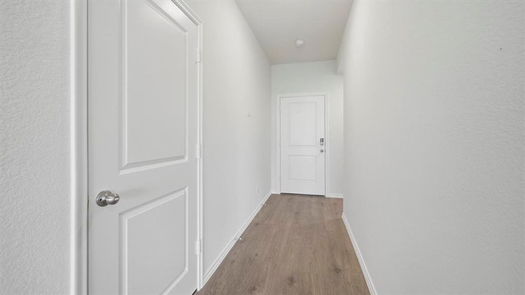 Hall with baseboards and wood finished floors Hall with baseboards and wood finished floors