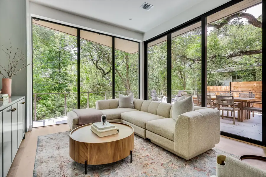 Floor-to-ceiling windows with expansive tree canopy exposure