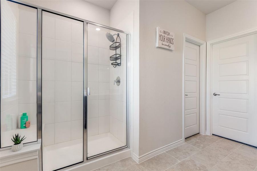 Full bathroom featuring a stall shower and tile patterned flooring Full bathroom featuring a stall shower and tile patterned flooring