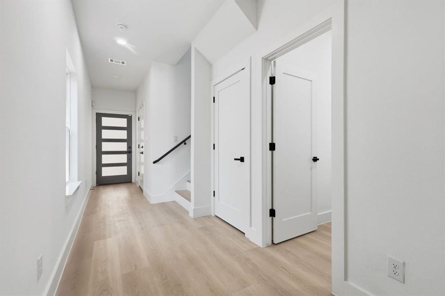 Hallway with stairway and light wood-style floors