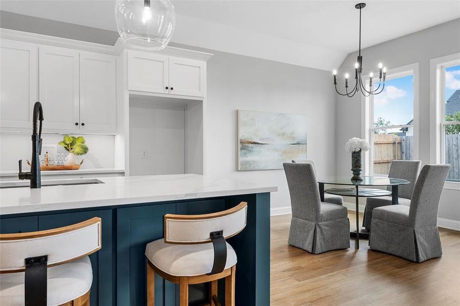 Dining room featuring light wood-style flooring, vaulted ceiling, and a chandelier Dining room featuring light wood-style flooring, vaulted ceiling, and a chandelier