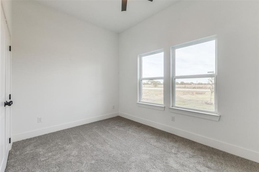 Carpeted spare room with ceiling fan