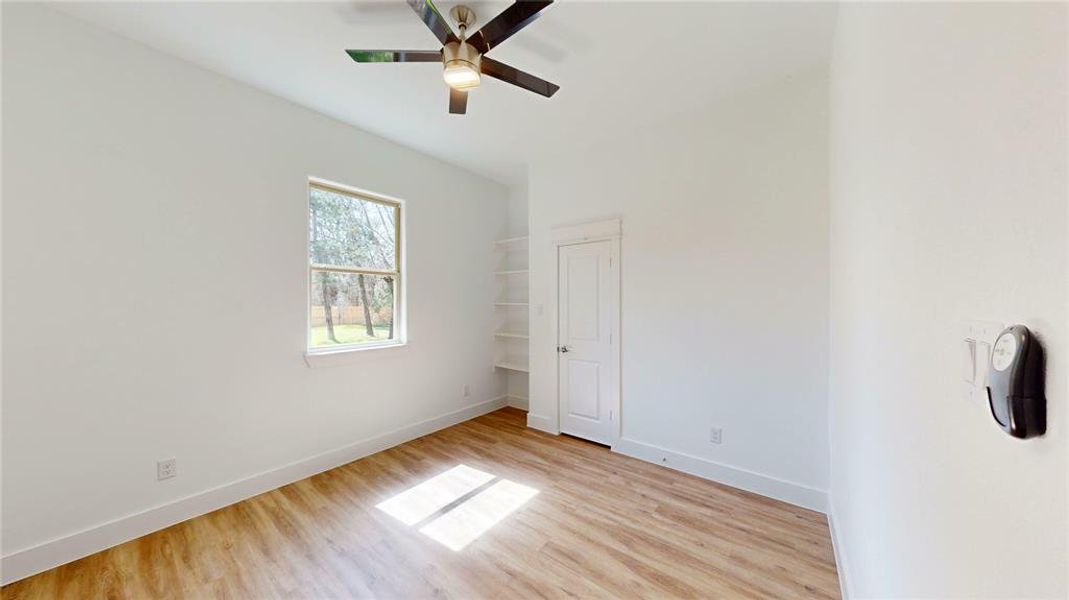 Unfurnished bedroom with light wood-style floors, ceiling fan, and baseboards