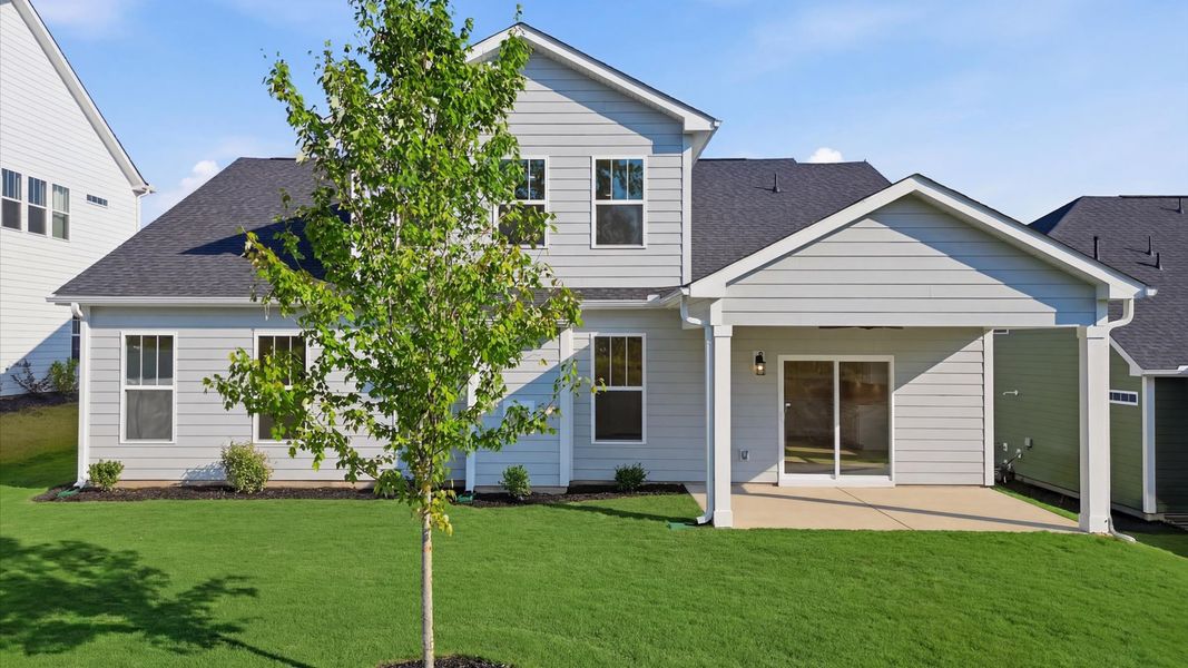 Warm and inviting outdoor living space with a covered rear porch and tasteful finishes at Wells Crossing
