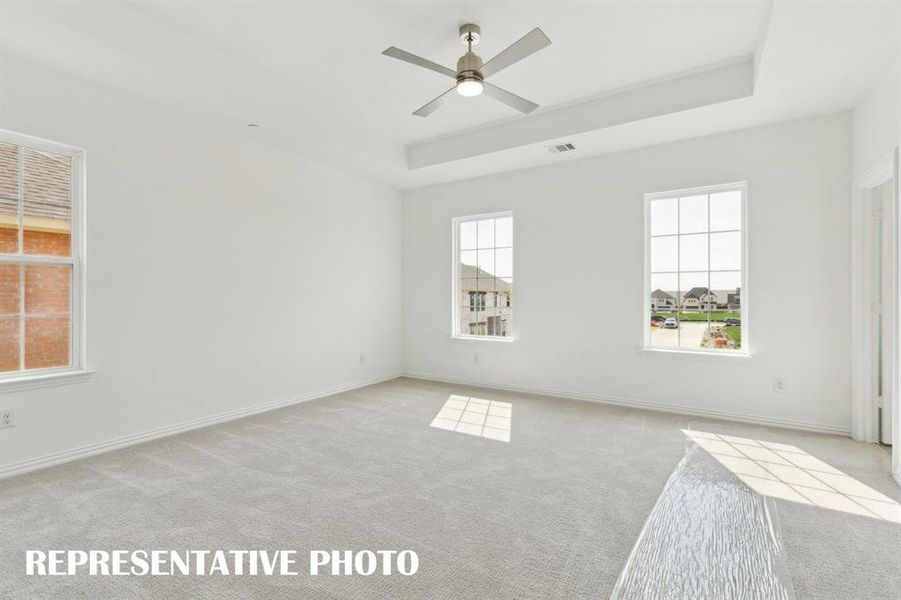 Offering high ceilings, large windows and plush carpeting, this owner's bedroom is a peaceful retreat where you can relax and renew.  REPRESENTATIVE PHOTO