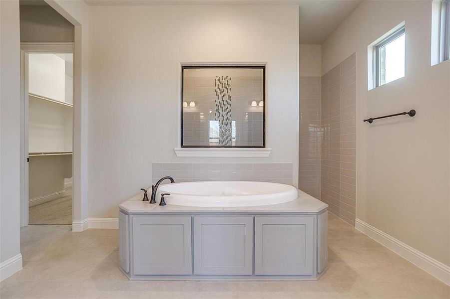 Bathroom with a bathtub and tile patterned floors