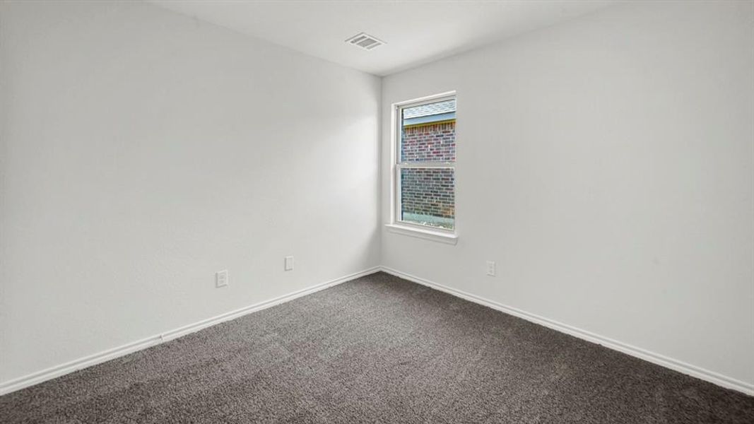 Neutral-toned room featuring a single window with white trim, gray carpeting, and white baseboards