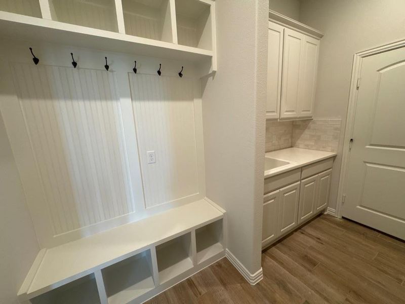 Built-in mudroom bench with cubby storage and upper shelving
