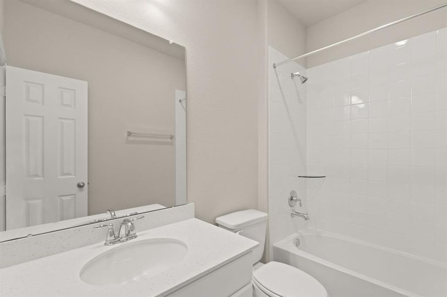 The secondary bath features tile flooring, white cabinetry and light countertops and a shower/tub combo. Perfect for accommodating any visiting family and friends.