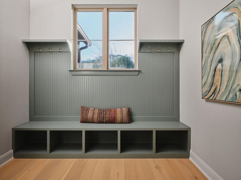 The mudroom drop-zone just off the garage combines style and functionality, offering a perfect spot to keep your keys, coats, and shoes neatly tucked away.