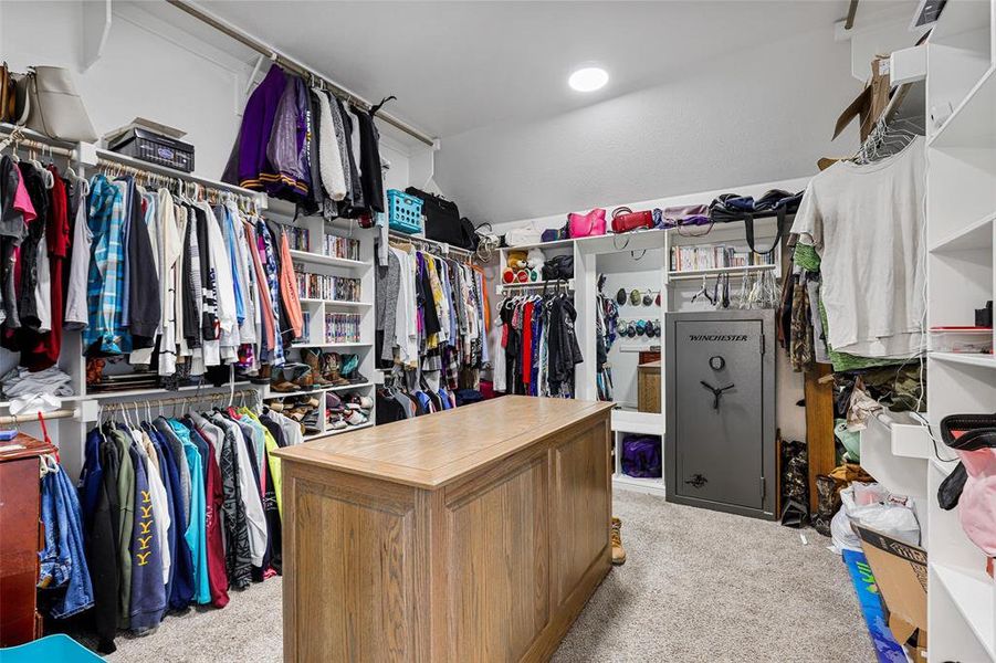 Walk in closet with lofted ceiling and light carpet