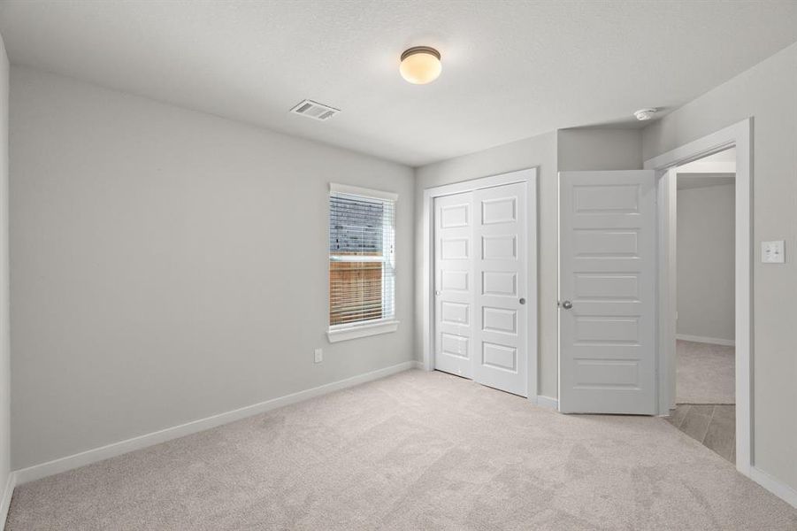 Generously sized secondary bedrooms featuring spacious closets, soft and inviting carpeting underfoot, large windows allowing plenty of natural light, and the added touch of privacy blinds for your personal retreat.Sample photo of completed home with similar floor plan. As-built interior colors and selections may vary.