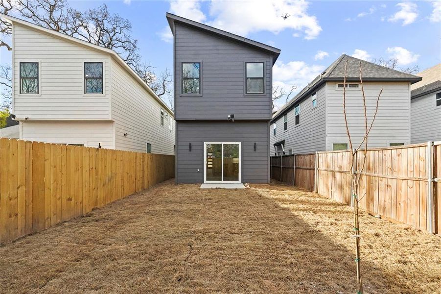 Rear view of house featuring a fenced backyard