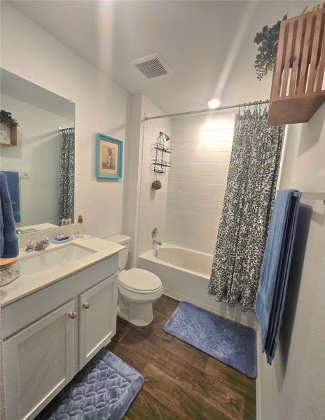 Bathroom featuring wood-finish flooring and a white vanity with an integrated sink