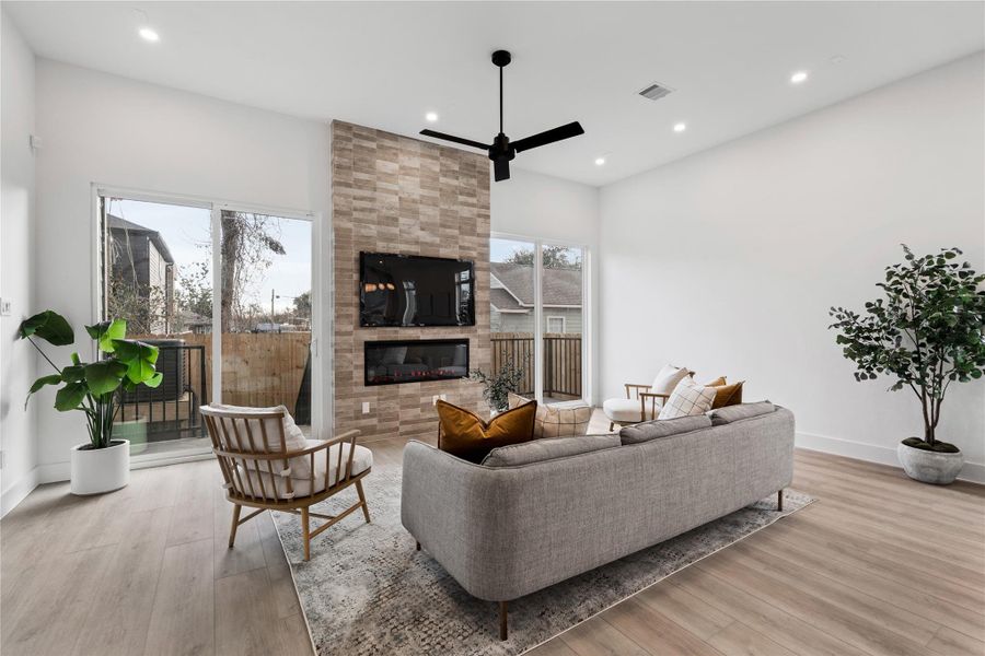 Anchored by a striking vertical hearth, the room opens gracefully to the balcony through dual glass doors. Clean architecture and warm accents create a setting made for unwinding.