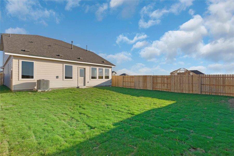Rear view of house featuring a fenced backyard