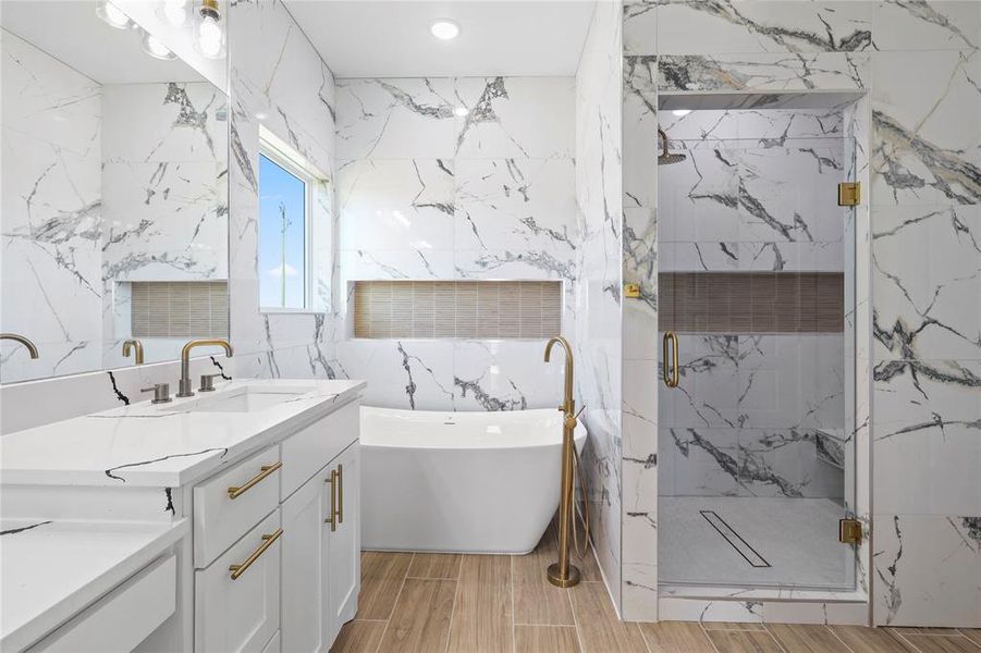 Full bath with vanity, a soaking tub, a marble finish shower, wood finish floors, and tile walls Full bath with vanity, a soaking tub, a marble finish shower, wood finish floors, and tile walls