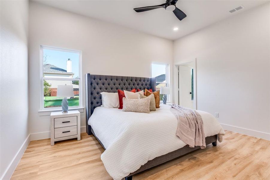 Bedroom featuring light wood-style flooring, a ceiling fan, and recessed lighting Bedroom featuring light wood-style flooring, a ceiling fan, and recessed lighting