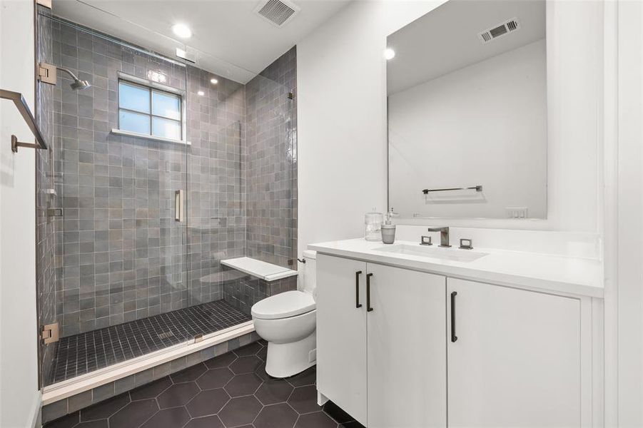 Guest house full bathroom with dark tile patterned flooring, vanity, a shower stall, and recessed lighting