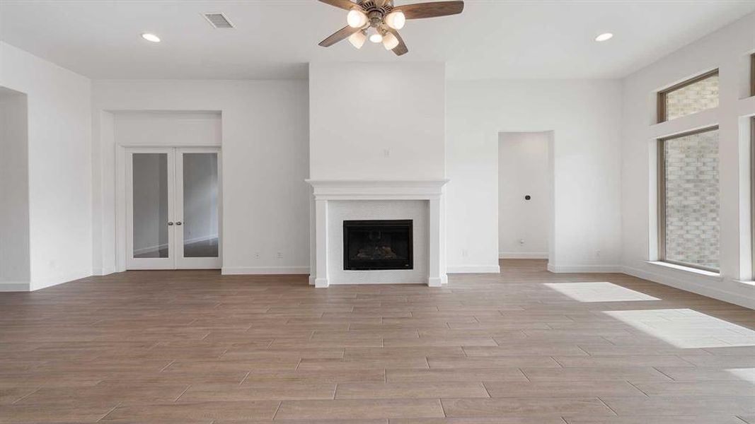 Unfurnished living room featuring ceiling fan