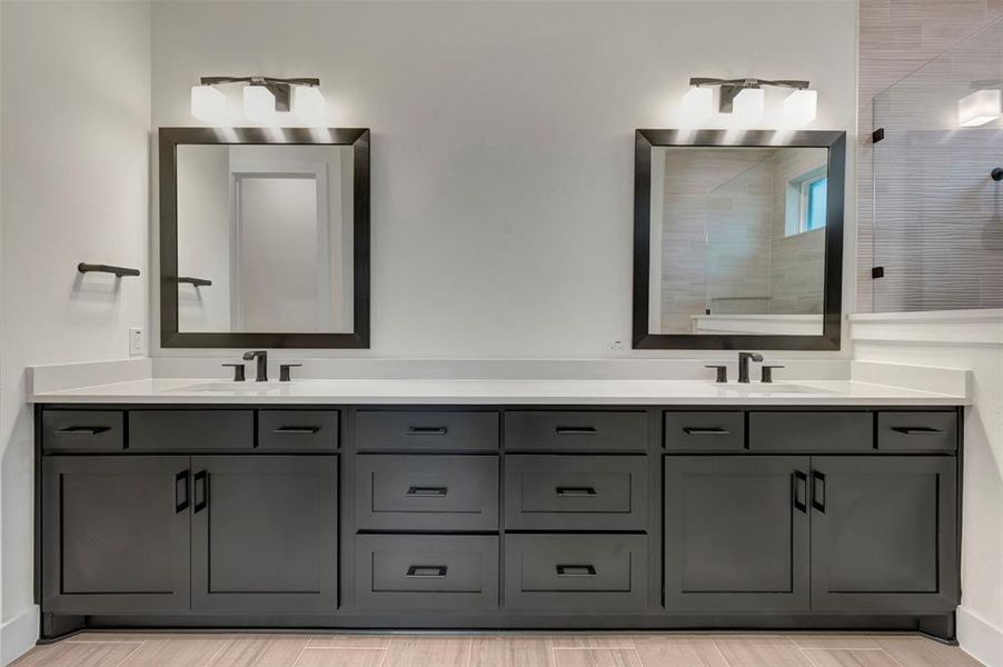 Owners bath featuring double vanity and a tile shower