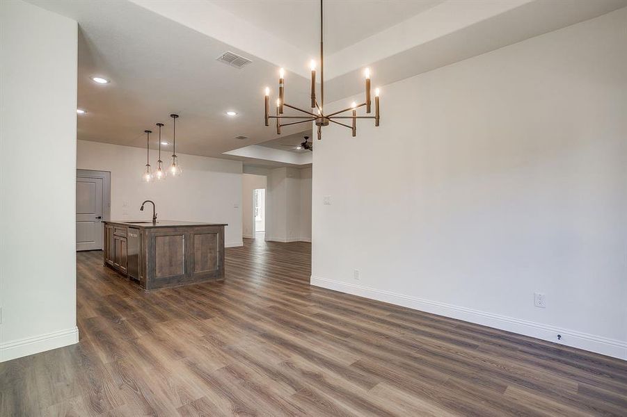Unfurnished dining area with a chandelier, dark wood-style floors, and recessed lighting