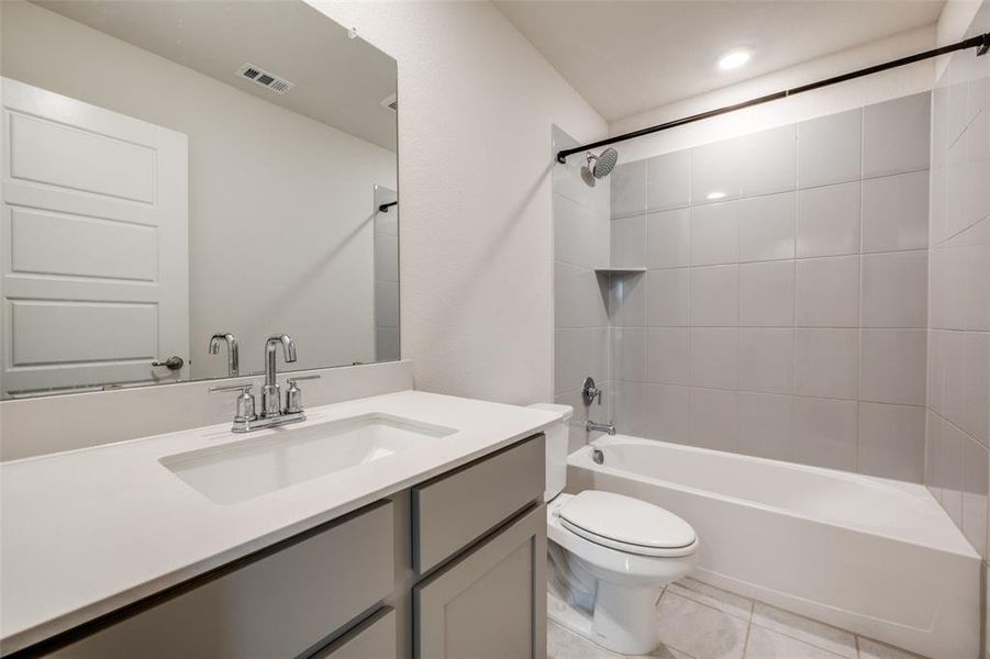 Bathroom with tub / shower combination, vanity, and light tile patterned floors