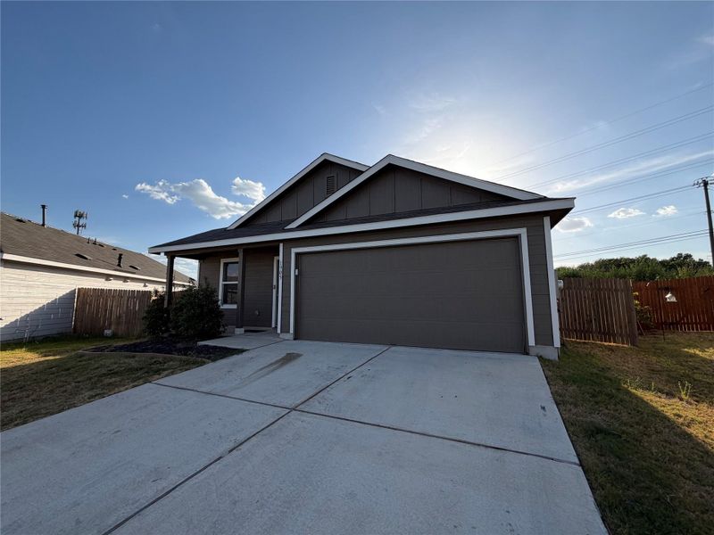 Clean concrete driveway leads to an attached double garage under a classic gabled roofline.