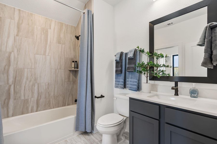 A well-appointed secondary bathroom featuring a tub/shower combination accented by tile work that extends seamlessly to the ceiling, creating a clean and sophisticated finish. A well-appointed secondary bathroom featuring a tub/shower combination accented by tile work that extends seamlessly to the ceiling, creating a clean and sophisticated finish.