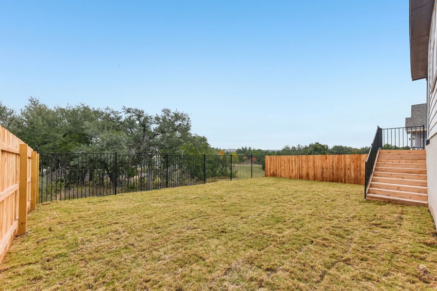 A fenced in yard with trees. A fenced in yard with trees.