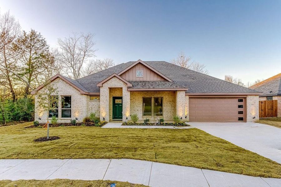 View of front of home featuring a front yard and a garage