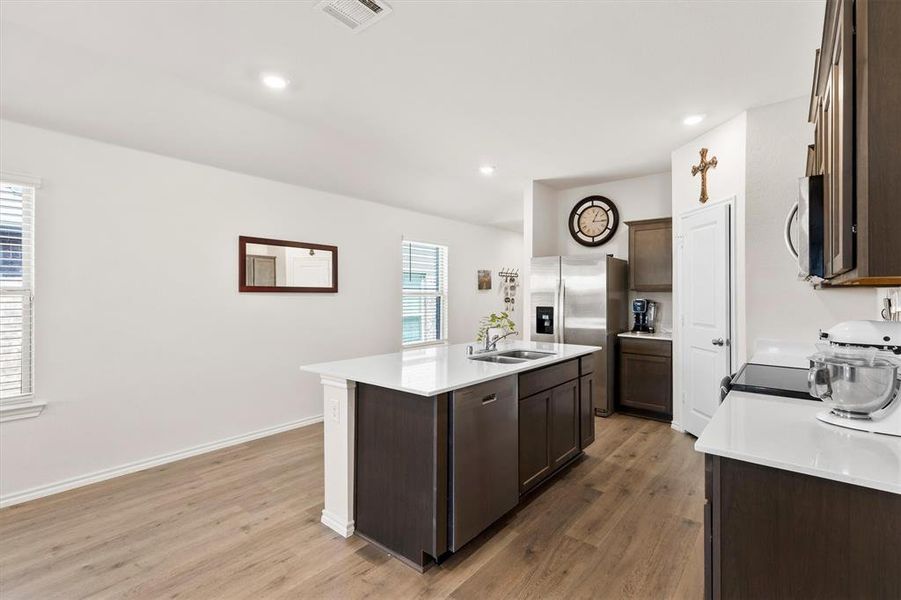 Kitchen featuring dark wood finish cabinets, a center island with sink, stainless steel appliances, and recessed lighting Kitchen featuring dark wood finish cabinets, a center island with sink, stainless steel appliances, and recessed lighting