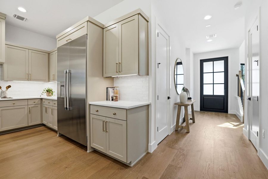 Kitchen featuring built in fridge, light wood-type flooring, recessed lighting, cream cabinets, and gray cabinetry